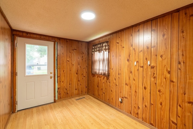 421 Moore St, Blue Earth, MN 56013 - foyer entrance featuring a textured ceiling, light wood-style floors, and wood walls