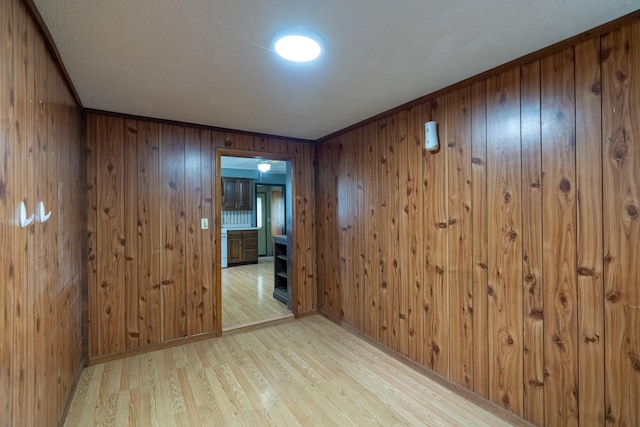 421 Moore St, Blue Earth, MN 56013 - empty room with light wood finished floors, wood walls, and a textured ceiling