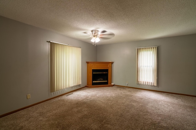 421 Moore St, Blue Earth, MN 56013 - unfurnished living room with light colored carpet, ceiling fan, a fireplace with raised hearth, and a textured ceiling