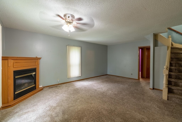 421 Moore St, Blue Earth, MN 56013 - unfurnished living room featuring stairs, carpet, a glass covered fireplace, a ceiling fan, and a textured ceiling