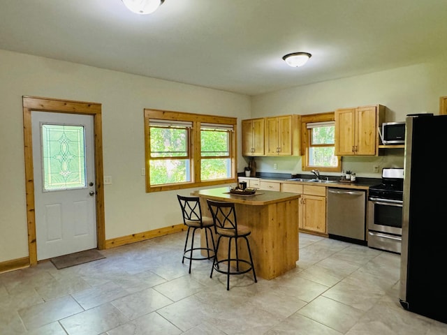 2795 40th St NW, Hackensack, MN 56452 - kitchen featuring appliances with stainless steel finishes, a breakfast bar, a center island, and dark countertops