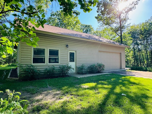 2795 40th St NW, Hackensack, MN 56452 - view of side of property with a lawn, a garage, driveway, and a shingled roof