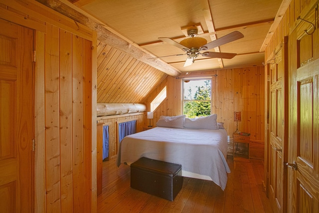 2338 Olson Rd, Blackhoof Twp, MN 55718 - bedroom featuring wooden walls, a wood ceiling with exposed beams, wood-type flooring, and ceiling fan