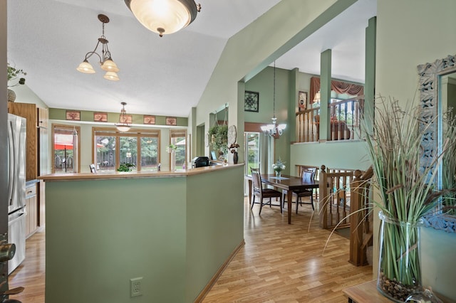 6469 Deerwood Ln N, Maple Grove, MN 55369 - kitchen featuring vaulted ceiling, a chandelier, plenty of natural light, stainless steel fridge, and light wood-style floors