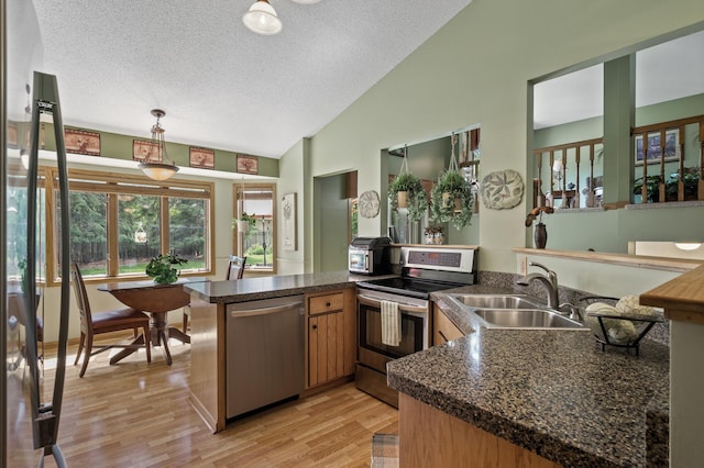 6469 Deerwood Ln N, Maple Grove, MN 55369 - kitchen with appliances with stainless steel finishes, a peninsula, lofted ceiling, dark countertops, and a textured ceiling