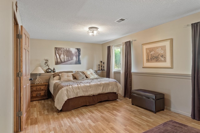 6469 Deerwood Ln N, Maple Grove, MN 55369 - bedroom featuring light wood finished floors and a textured ceiling