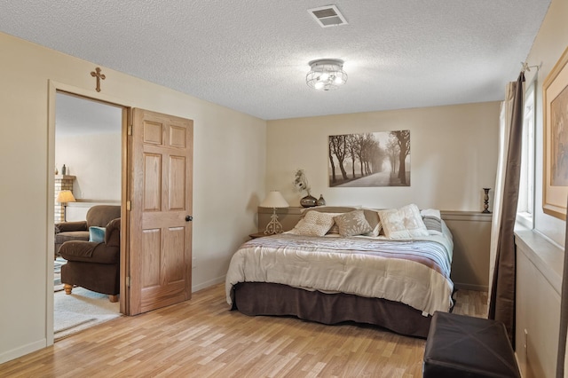6469 Deerwood Ln N, Maple Grove, MN 55369 - bedroom featuring light wood finished floors and a textured ceiling