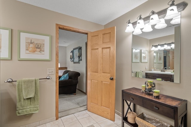 6469 Deerwood Ln N, Maple Grove, MN 55369 - ensuite bathroom featuring tile patterned floors, vanity, and a textured ceiling