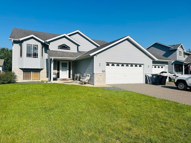 11162 Olympia Ave, Becker, MN 55308 - split level home featuring a garage, a front yard, asphalt driveway, roof with shingles, and brick siding
