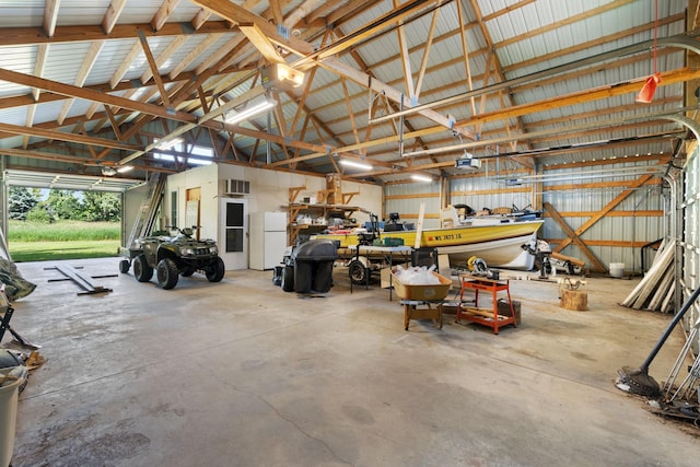 2282 71st St, Georgetown Twp, WI 54853 - garage featuring freestanding refrigerator, a garage door opener, and a wall unit AC