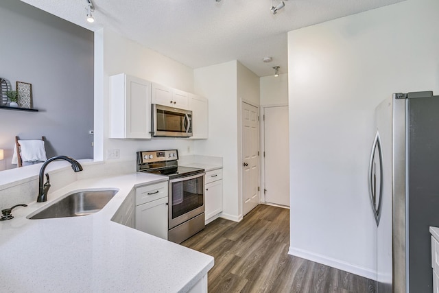 16835 78th Pl N, Maple Grove, MN 55311 - kitchen featuring appliances with stainless steel finishes, dark wood-style floors, white cabinetry, a textured ceiling, and rail lighting