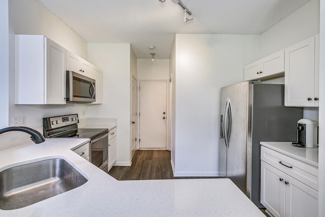 16835 78th Pl N, Maple Grove, MN 55311 - kitchen with stainless steel appliances, dark wood-type flooring, white cabinetry, rail lighting, and a textured ceiling