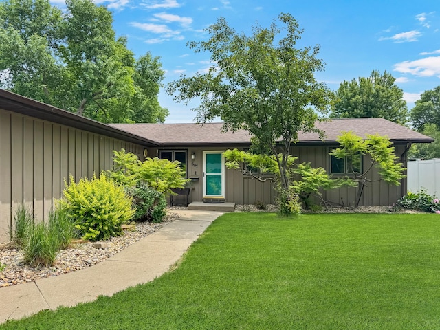 607 1st St, Marshall, MN 56258 - view of front of home with board and batten siding, a front yard, and roof with shingles