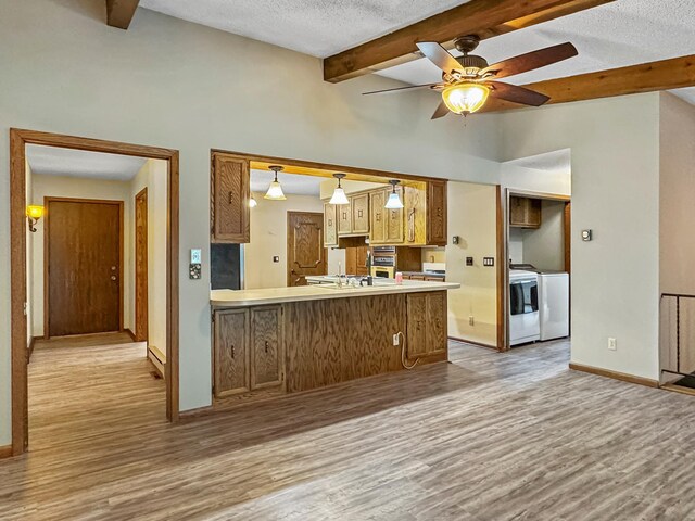 607 1st St, Marshall, MN 56258 - kitchen featuring wood finished floors, a textured ceiling, independent washer and dryer, a peninsula, and ceiling fan