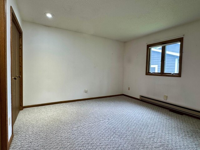 607 1st St, Marshall, MN 56258 - spare room with carpet, a textured ceiling, recessed lighting, and a baseboard heating unit
