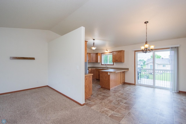 3661 Taylor St S, Fargo, ND 58104 - kitchen with a peninsula, a chandelier, hanging light fixtures, light countertops, and lofted ceiling