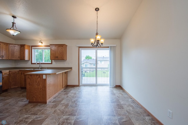 3661 Taylor St S, Fargo, ND 58104 - kitchen featuring lofted ceiling, a peninsula, a chandelier, decorative light fixtures, and stone finish floors
