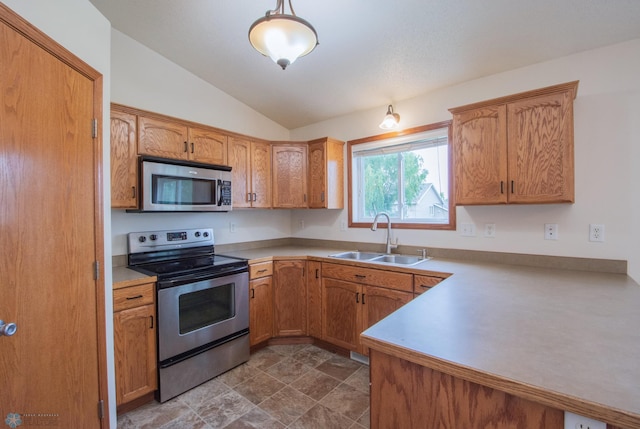 3661 Taylor St S, Fargo, ND 58104 - kitchen with appliances with stainless steel finishes, vaulted ceiling, light countertops, a peninsula, and brown cabinets