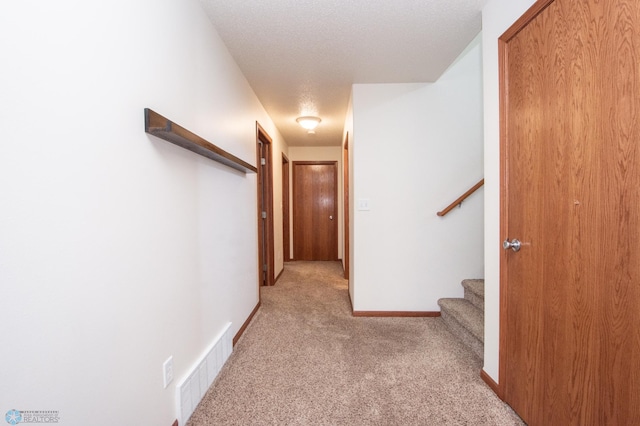 3661 Taylor St S, Fargo, ND 58104 - hall with light carpet, stairway, and a textured ceiling