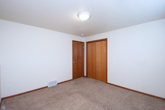 3661 Taylor St S, Fargo, ND 58104 - unfurnished bedroom featuring carpet, a textured ceiling, and a closet