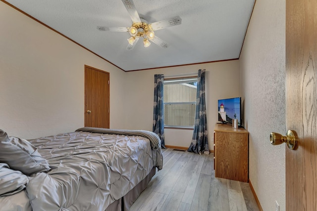 57975 226th St, Litchfield, MN 55355 - bedroom with light wood finished floors, crown molding, a textured wall, a ceiling fan, and a textured ceiling