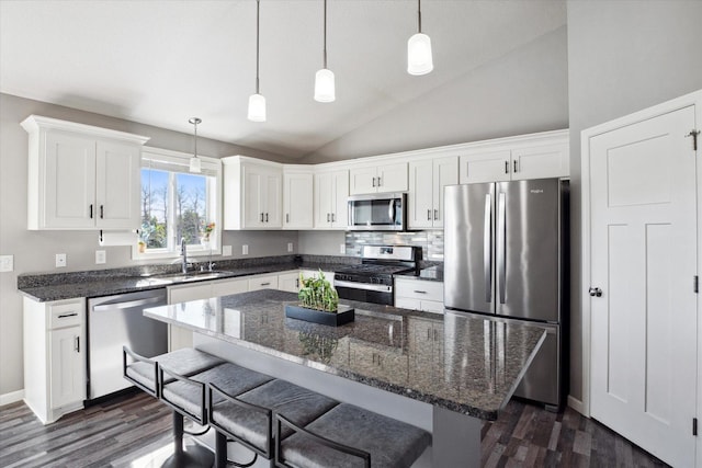 15005 Quintana St NW, Ramsey, MN 55303 - kitchen with appliances with stainless steel finishes, dark wood-type flooring, lofted ceiling, white cabinetry, and a breakfast bar