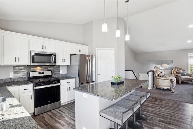 15005 Quintana St NW, Ramsey, MN 55303 - kitchen with appliances with stainless steel finishes, decorative backsplash, dark wood finished floors, white cabinetry, and high vaulted ceiling
