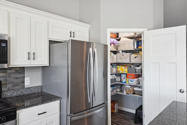 15005 Quintana St NW, Ramsey, MN 55303 - kitchen with stainless steel appliances, decorative backsplash, dark stone countertops, and white cabinetry
