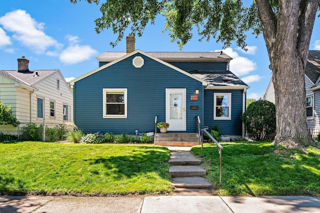 1890 Sheridan Ave, Saint Paul, MN 55116 - bungalow-style house featuring entry steps, a front yard, roof with shingles, and a chimney