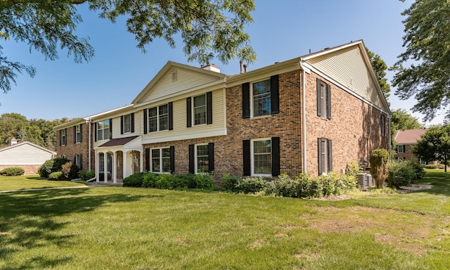 2051 Carriage Dr SW Unit 2051D, Rochester, MN 55902 - view of front facade featuring brick siding, a front lawn, and a chimney