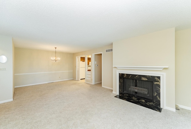 2051 Carriage Dr SW Unit 2051D, Rochester, MN 55902 - unfurnished living room featuring a chandelier, carpet floors, a high end fireplace, and a textured ceiling