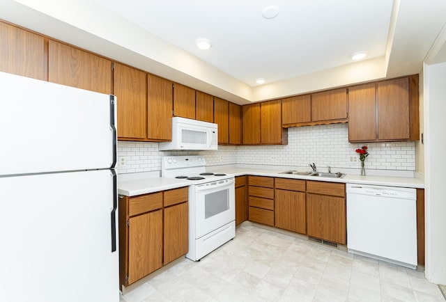 2051 Carriage Dr SW Unit 2051D, Rochester, MN 55902 - kitchen with white appliances, light countertops, brown cabinetry, and decorative backsplash