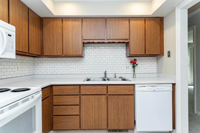 2051 Carriage Dr SW Unit 2051D, Rochester, MN 55902 - kitchen with white appliances, light countertops, backsplash, and brown cabinets