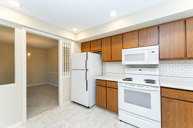 2051 Carriage Dr SW Unit 2051D, Rochester, MN 55902 - kitchen with white appliances, light countertops, brown cabinetry, and decorative backsplash