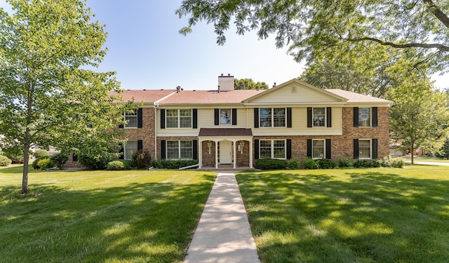 2051 Carriage Dr SW Unit 2051D, Rochester, MN 55902 - view of front of home featuring brick siding, a front lawn, and a chimney