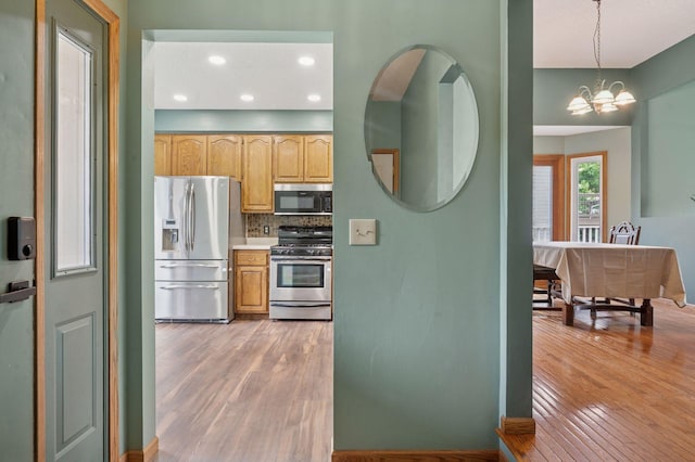 10989 Eagle Lake Blvd, Maple Grove, MN 55369 - kitchen with stainless steel appliances, light wood-style floors, tasteful backsplash, a chandelier, and recessed lighting