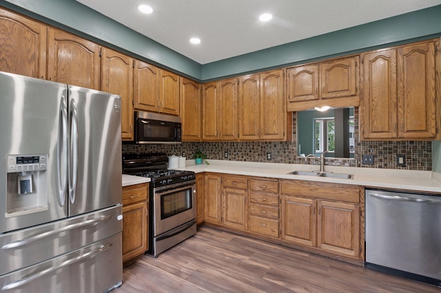 10989 Eagle Lake Blvd, Maple Grove, MN 55369 - kitchen featuring stainless steel appliances, brown cabinets, light countertops, backsplash, and recessed lighting