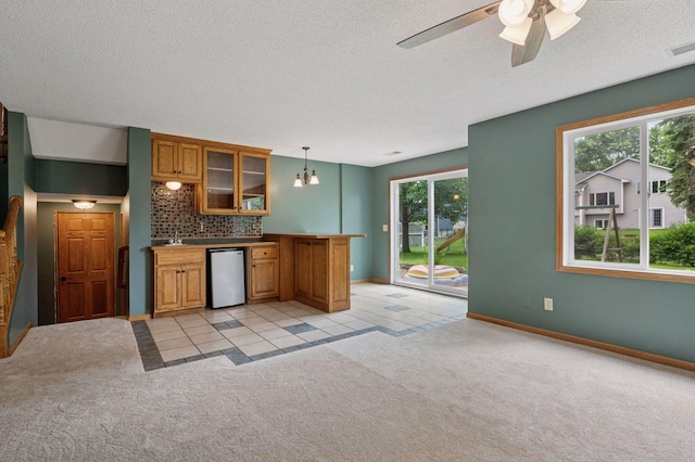 10989 Eagle Lake Blvd, Maple Grove, MN 55369 - kitchen with dishwasher, brown cabinetry, healthy amount of natural light, light carpet, and a textured ceiling