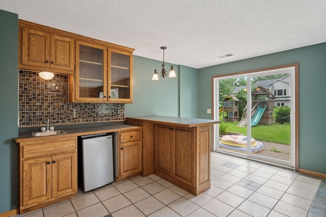 10989 Eagle Lake Blvd, Maple Grove, MN 55369 - kitchen featuring a peninsula, dishwashing machine, tasteful backsplash, brown cabinetry, and a textured ceiling