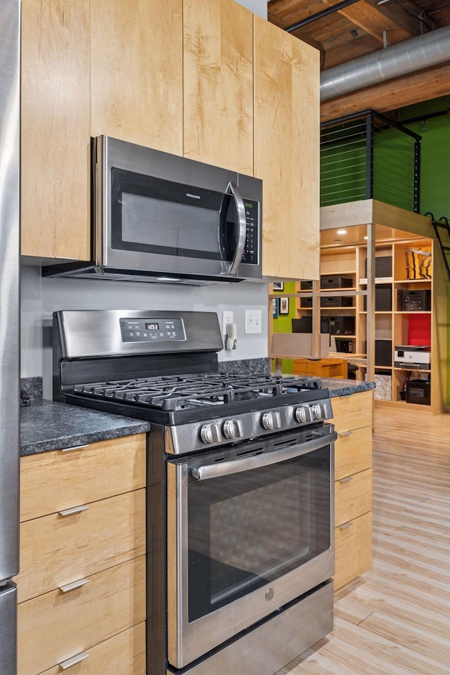 406 Wacouta St Unit 207, Saint Paul, MN 55101 - kitchen with appliances with stainless steel finishes, dark countertops, light wood-style flooring, and light brown cabinetry
