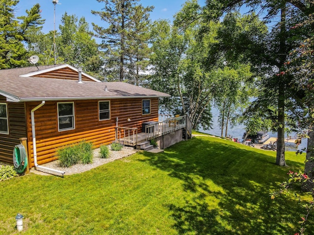 37566 Tulaby Lake Dr, Waubun, MN 56589 - rear view of house with a lawn, a deck, roof with shingles, and faux log siding