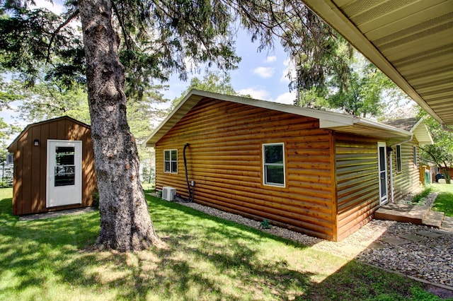 37566 Tulaby Lake Dr, Waubun, MN 56589 - view of property exterior featuring a lawn, a storage unit, and faux log siding