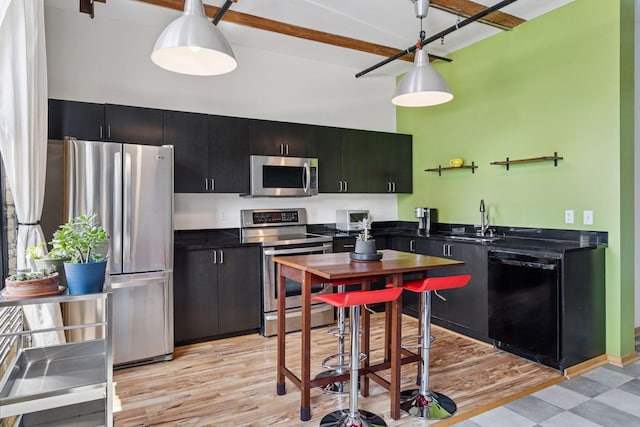 406 Wacouta St Unit 611, Saint Paul, MN 55101 - kitchen with stainless steel appliances, dark countertops, dark cabinets, a high ceiling, and light wood-type flooring