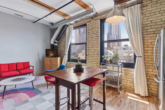 406 Wacouta St Unit 611, Saint Paul, MN 55101 - dining area featuring brick wall, a wood stove, and wood finished floors