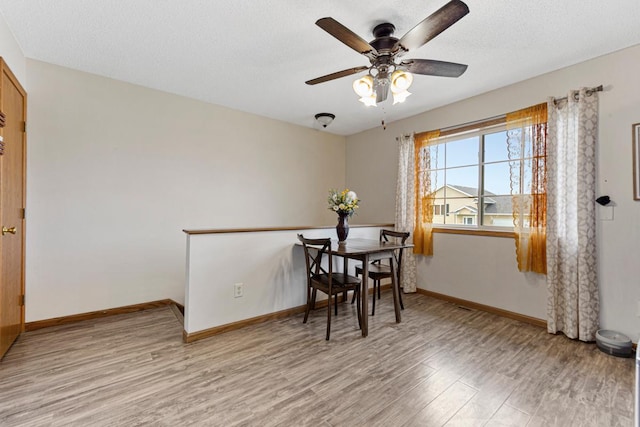 2115 Turpin St, Saint Peter, MN 56082 - dining room featuring light wood finished floors, a ceiling fan, and a textured ceiling