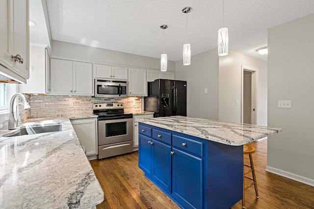 5245 Dufferin Dr, Savage, MN 55378 - kitchen featuring stainless steel appliances, blue cabinetry, decorative backsplash, white cabinets, and a kitchen breakfast bar