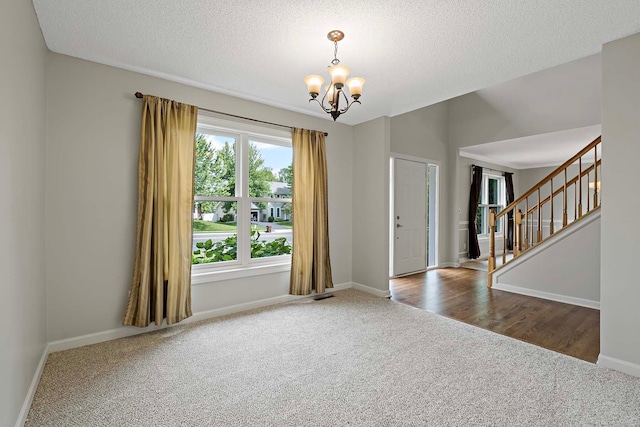 5245 Dufferin Dr, Savage, MN 55378 - carpeted empty room with a chandelier, stairway, and a textured ceiling