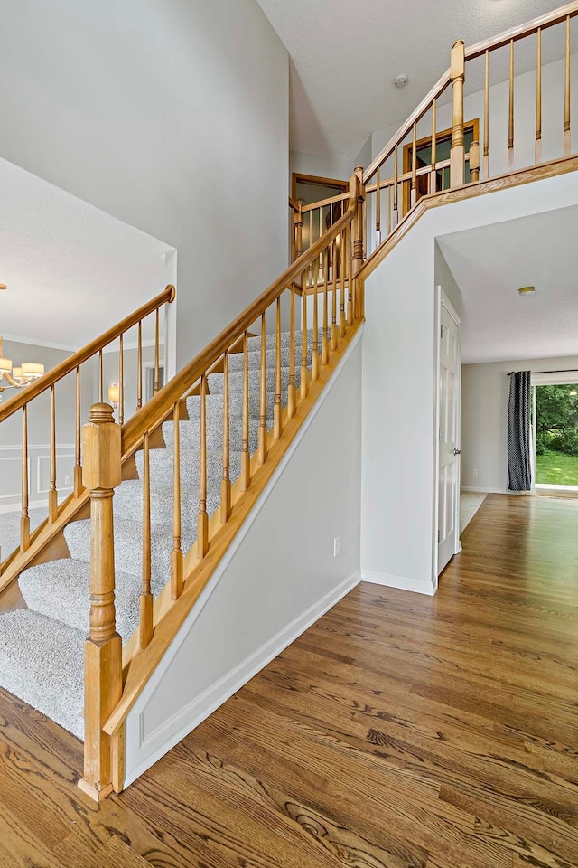 5245 Dufferin Dr, Savage, MN 55378 - stairway featuring wood finished floors, a chandelier, and a high ceiling
