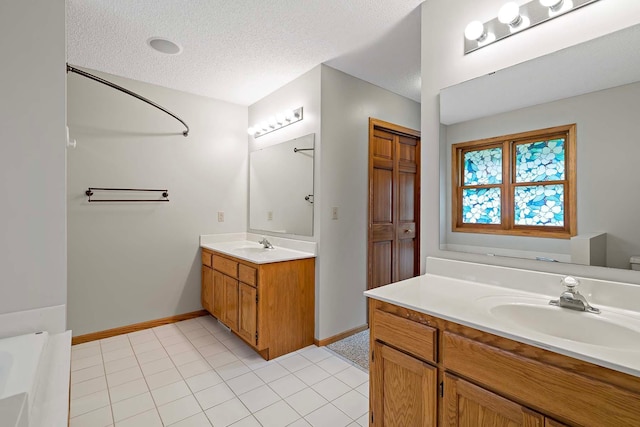 5245 Dufferin Dr, Savage, MN 55378 - bathroom featuring vanity, a textured ceiling, a tub to relax in, and tile patterned flooring