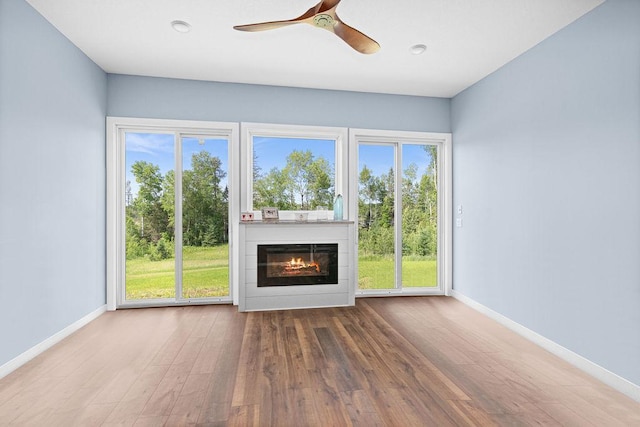 4335 Spring View Dr, Moose Lake, MN 55767 - unfurnished living room with wood finished floors, a ceiling fan, and a glass covered fireplace